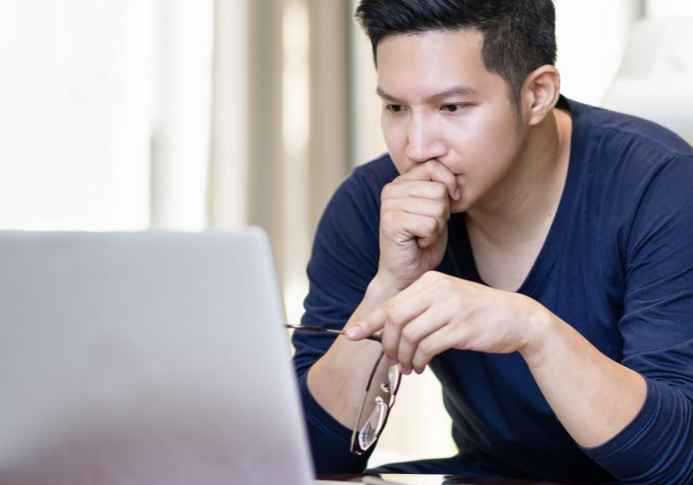 Person contemplating at laptop
